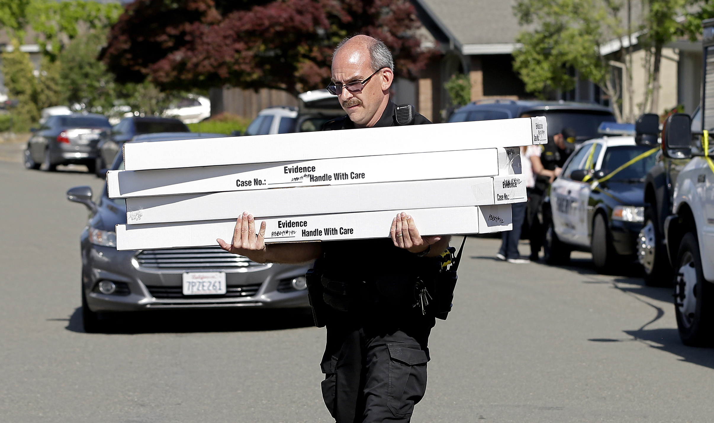 PHOTO: John Lopes, a crime scene investigator for the Sacramento County Sheriff's office, carries boxes of evidence taken from the home of murder suspect Joseph DeAngelo to a sheriff's vehicle, April 26, 2018, in Citrus Heights, Calif.