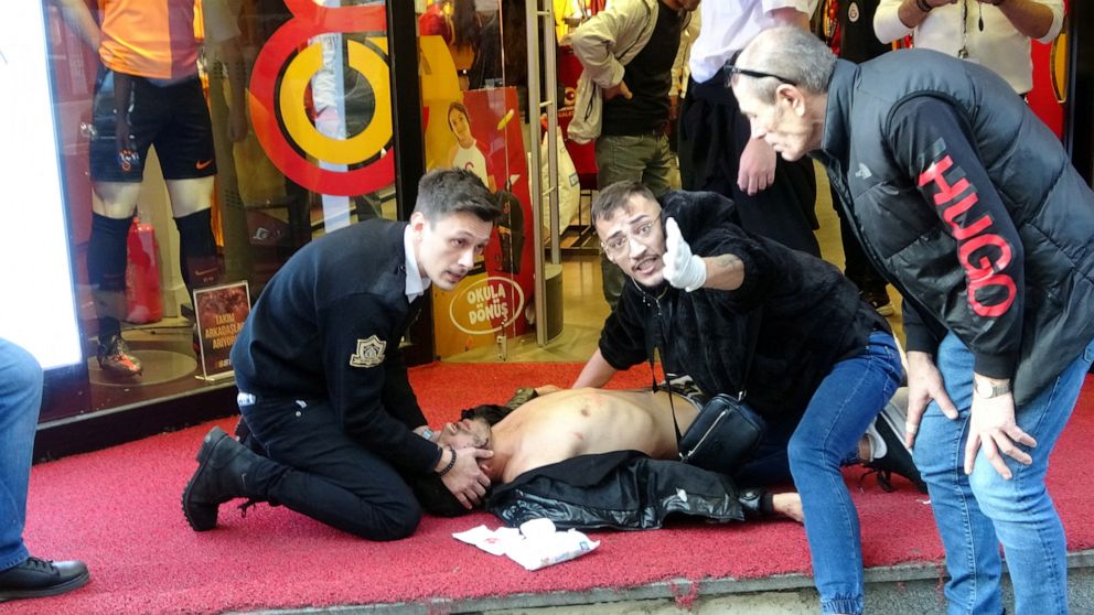 PHOTO: People attend a wounded man after an explosion in Istikla Street in central Istanbul, Nov. 13, 2022.