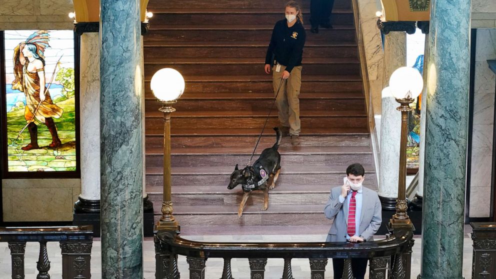 PHOTO: Deputy State Fire Marshal Kayla Riggs follows the agency's explosive detection dog, "Ringo," down the steps of the third floor at the Capitol in Jackson, Miss., Jan. 14, 2021.
