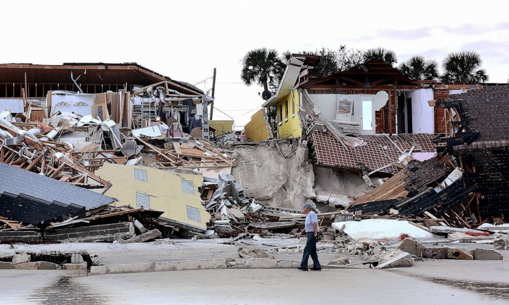 PHOTO: FILE - A man walks past homes that collapsed onto the beach due to the storm surge and resulting erosion caused by Hurricane Nicole, Nov. 11, 2022 in Wilbur-By-The-Sea, Fla.