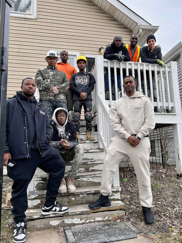 PHOTO: Faheem Muhammad and employees of the OASIS group stand in front of one of their houses in Chicago.