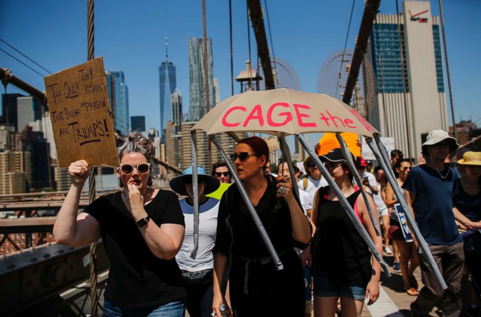 PHOTO: People take part in the nationwide "Families Belong Together" march as they walk over the Brooklyn Bridge on June 30, 2018 in New York City.