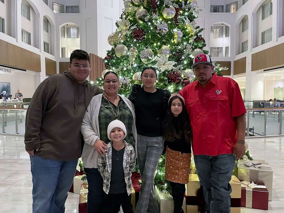 PHOTO: Miah and her family pose in front of a Christmas tree.