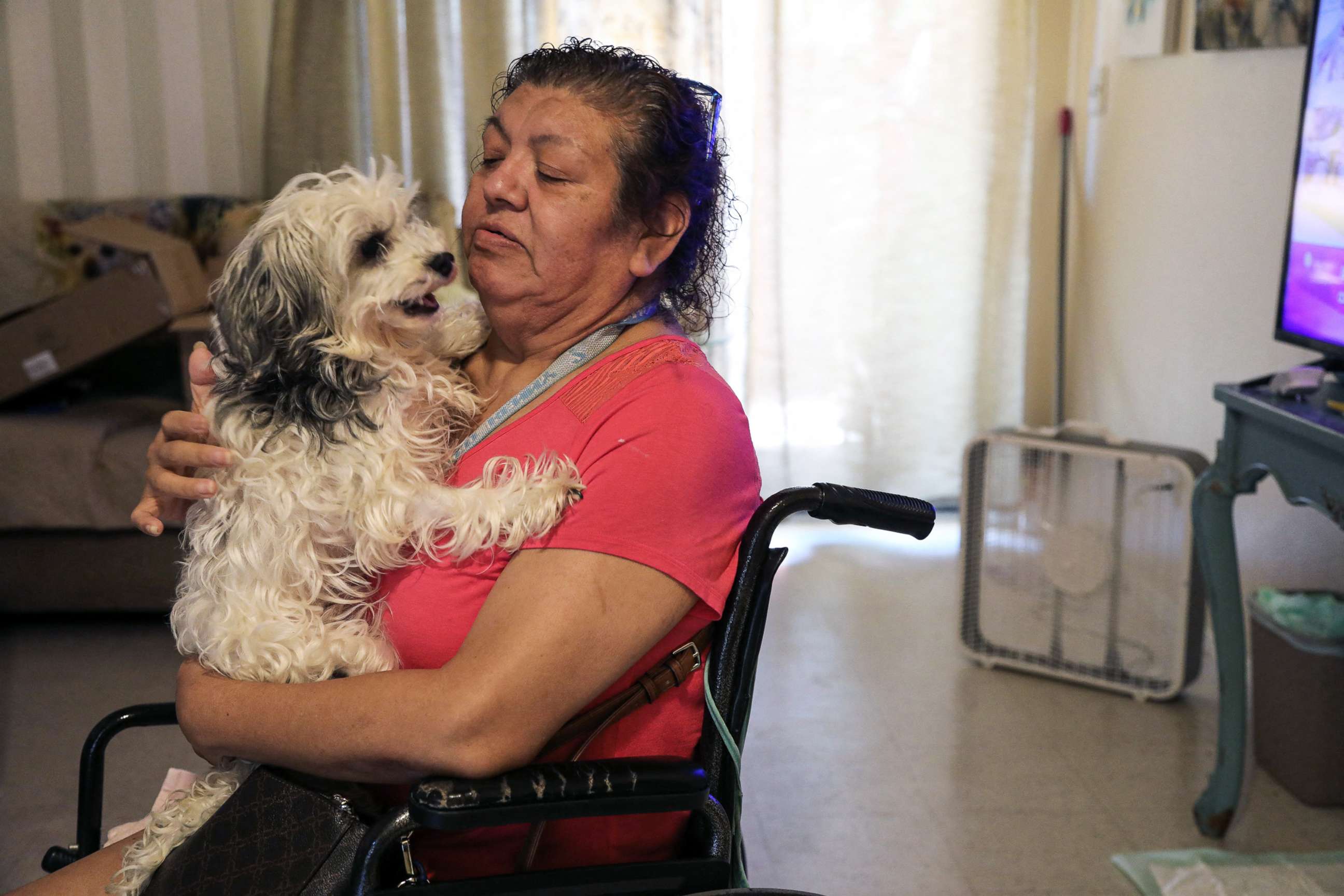 PHOTO: Juanita Alarcon holds her dog, Chloe, near a newly donated fan to help cope with the heat, in San Antonio, Texas, July 11, 2022.
