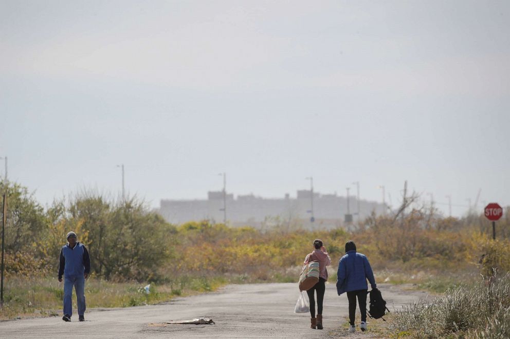 PHOTO: In this May 20, 2020, file photo, people walk on the road in the Far Rockaway section of Queens, NY.