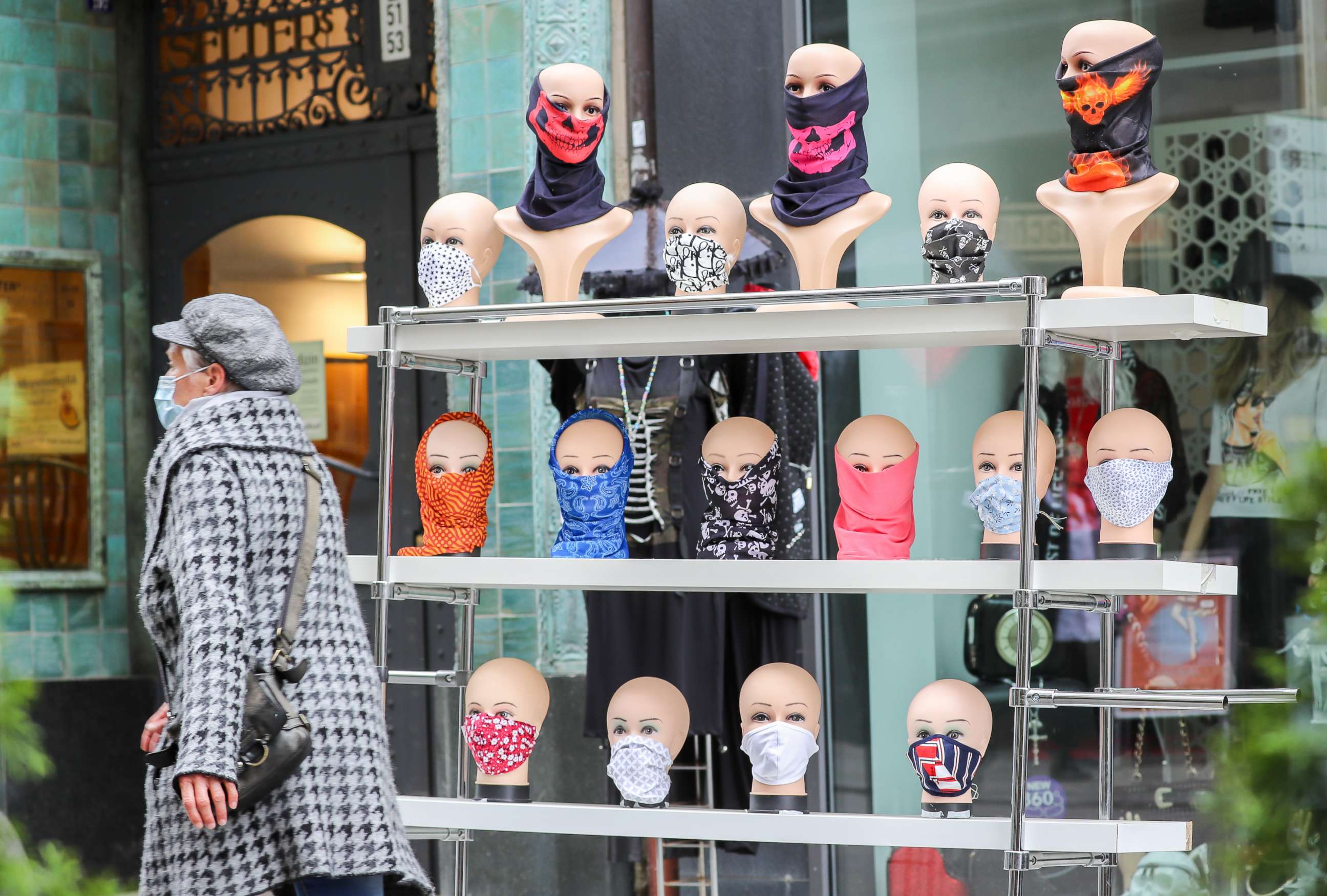 PHOTO: A sales shelf with the heads of mannequins with face masks stands in front of a shop in Leipzig's city centre.