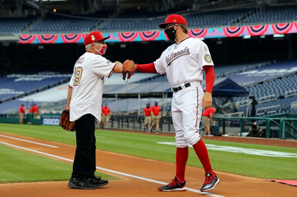 PHOTO: Dr. Anthony Fauci is greeted by Sean Doolittle of the Washington Nationals after throwing out the ceremonial first pitch prior to the game between the New York Yankees and the Washington Nationals at Nationals Park on July 23, 2020, in Washington.