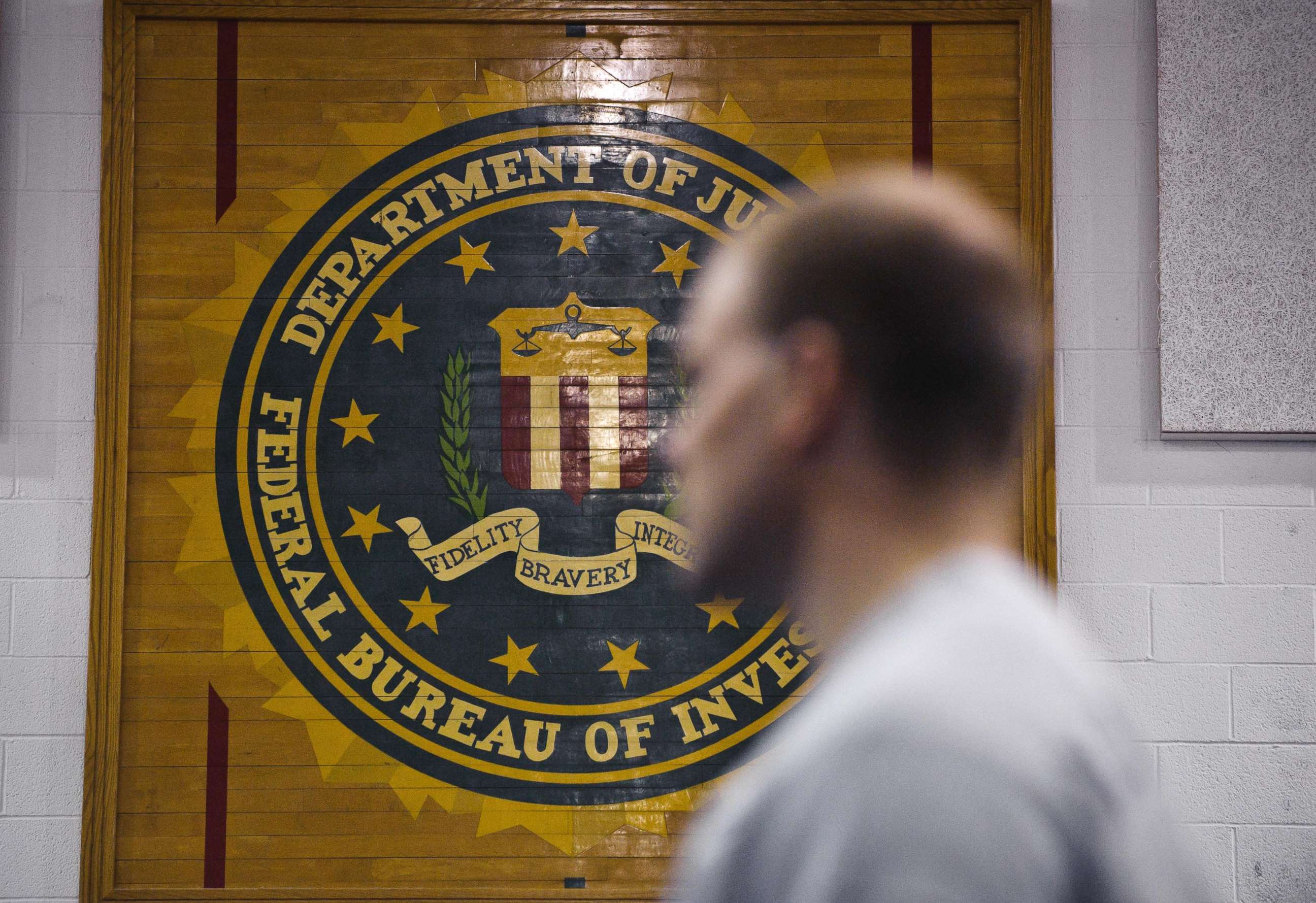 PHOTO: A new agent trainee walks by the FBI seal on a wall at the FBI Academy in Quantico, Va., in 2012.
