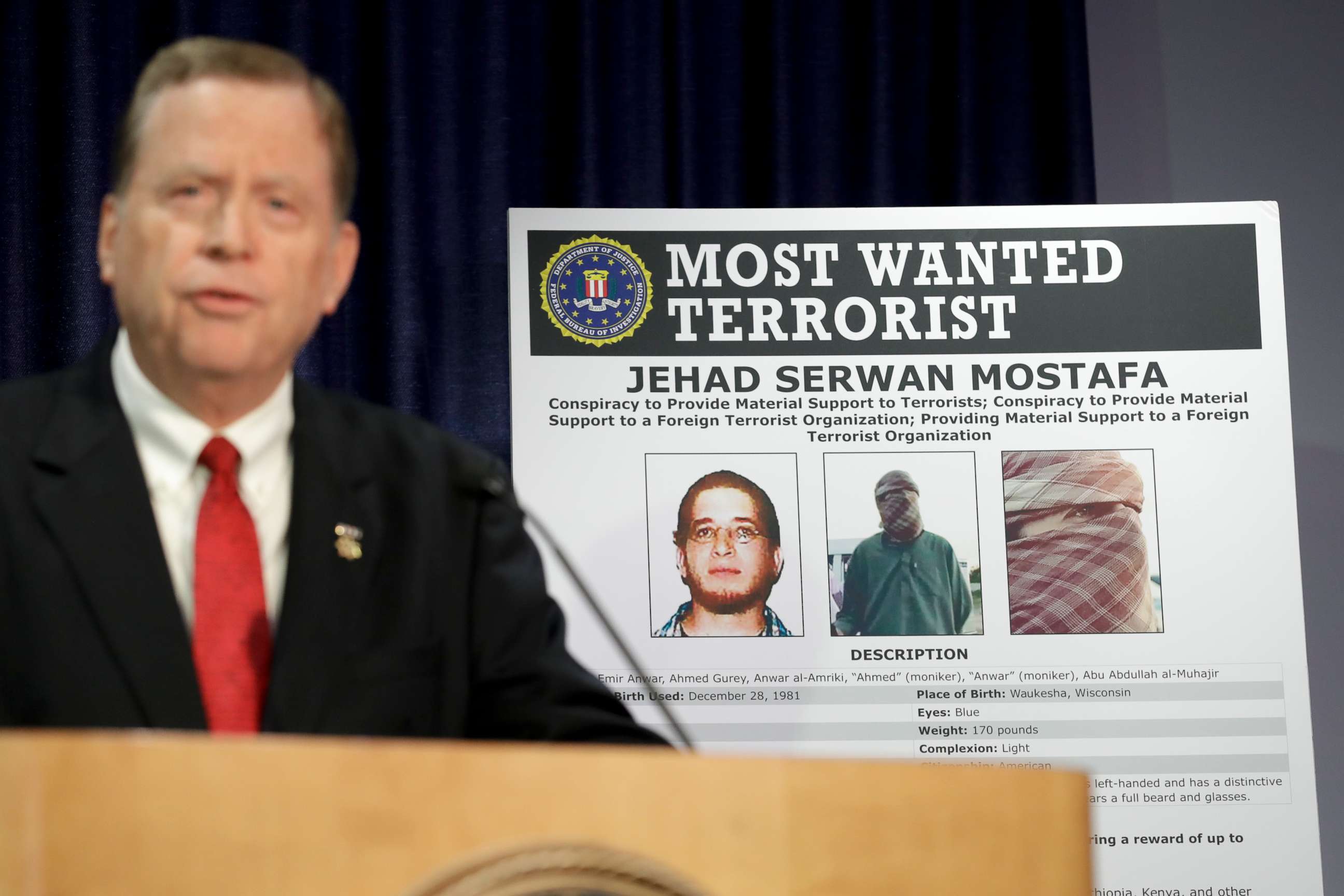 PHOTO: U.S Attorney Robert Brewer speaks in front of an FBI poster depicting Jehad Serwan Mostafa during a news conference Monday, Dec. 2, 2019, in San Diego.