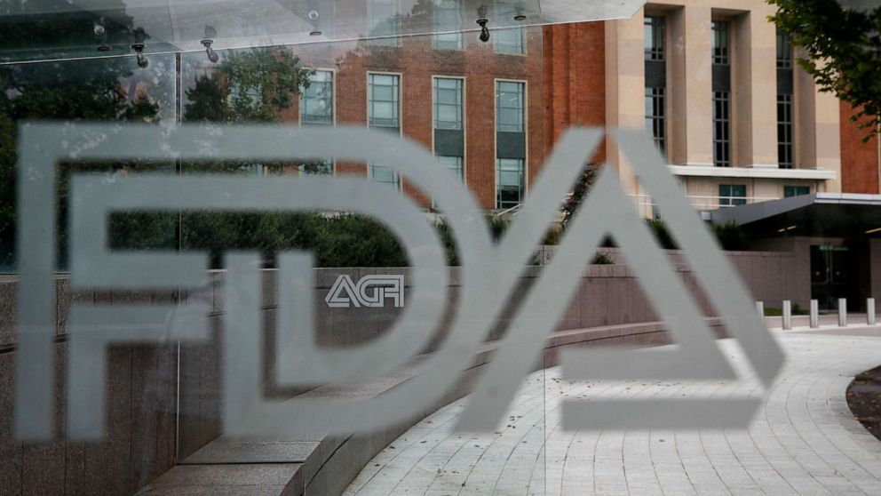 PHOTO: U.S. Food and Drug Administration building behind FDA logos at a bus stop on the agency's campus in Silver Spring, Md.