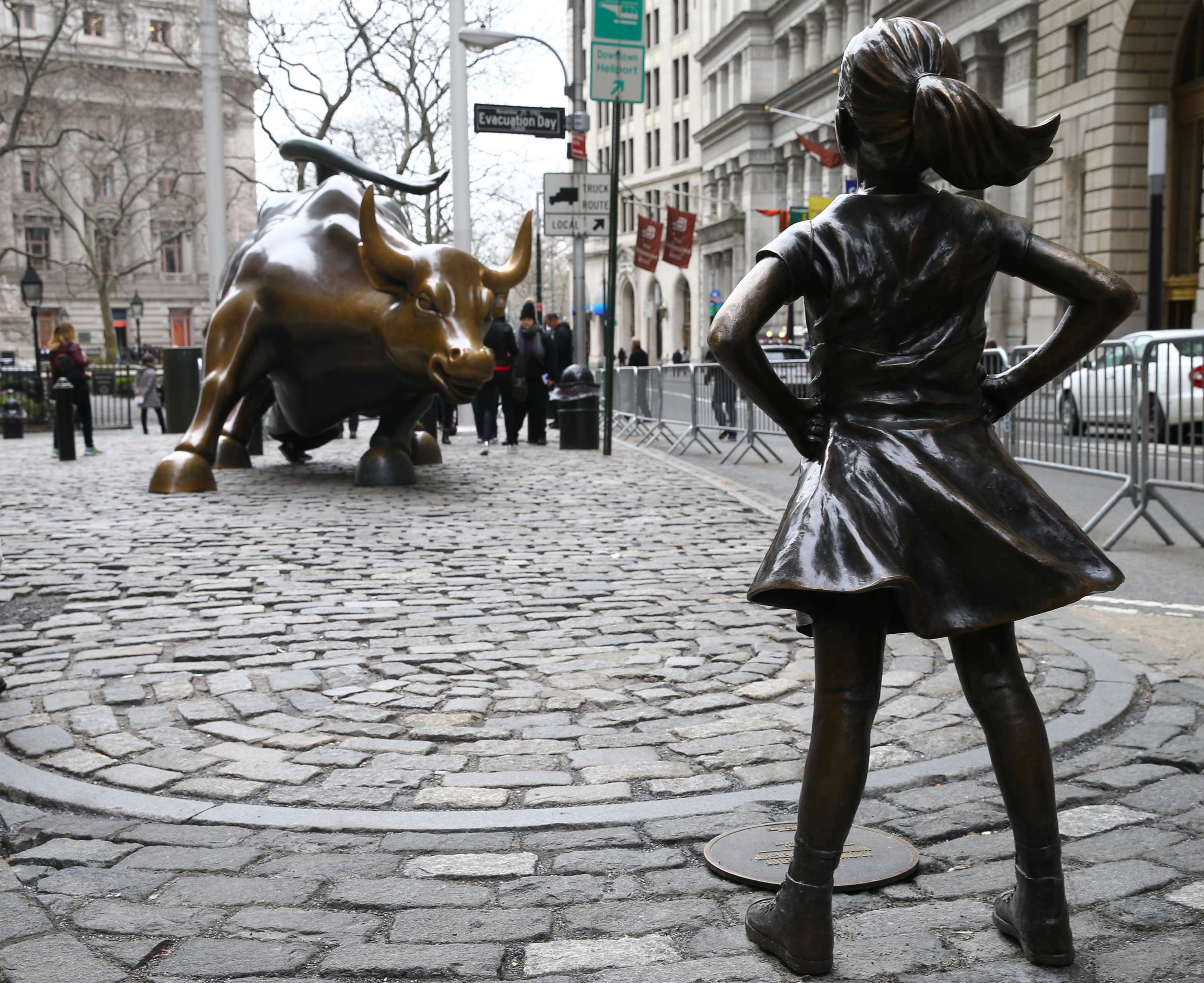 PHOTO: The "Fearless Girl" statue, a four-foot statue of a young girl, defiantly looks up the iconic Wall Street "Charging Bull" sculpture in New York, March 29, 2017. 