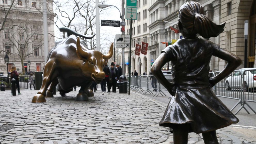 PHOTO: The "Fearless Girl" statue, a four-foot statue of a young girl, defiantly looks up the iconic Wall Street "Charging Bull" sculpture in New York, March 29, 2017. 