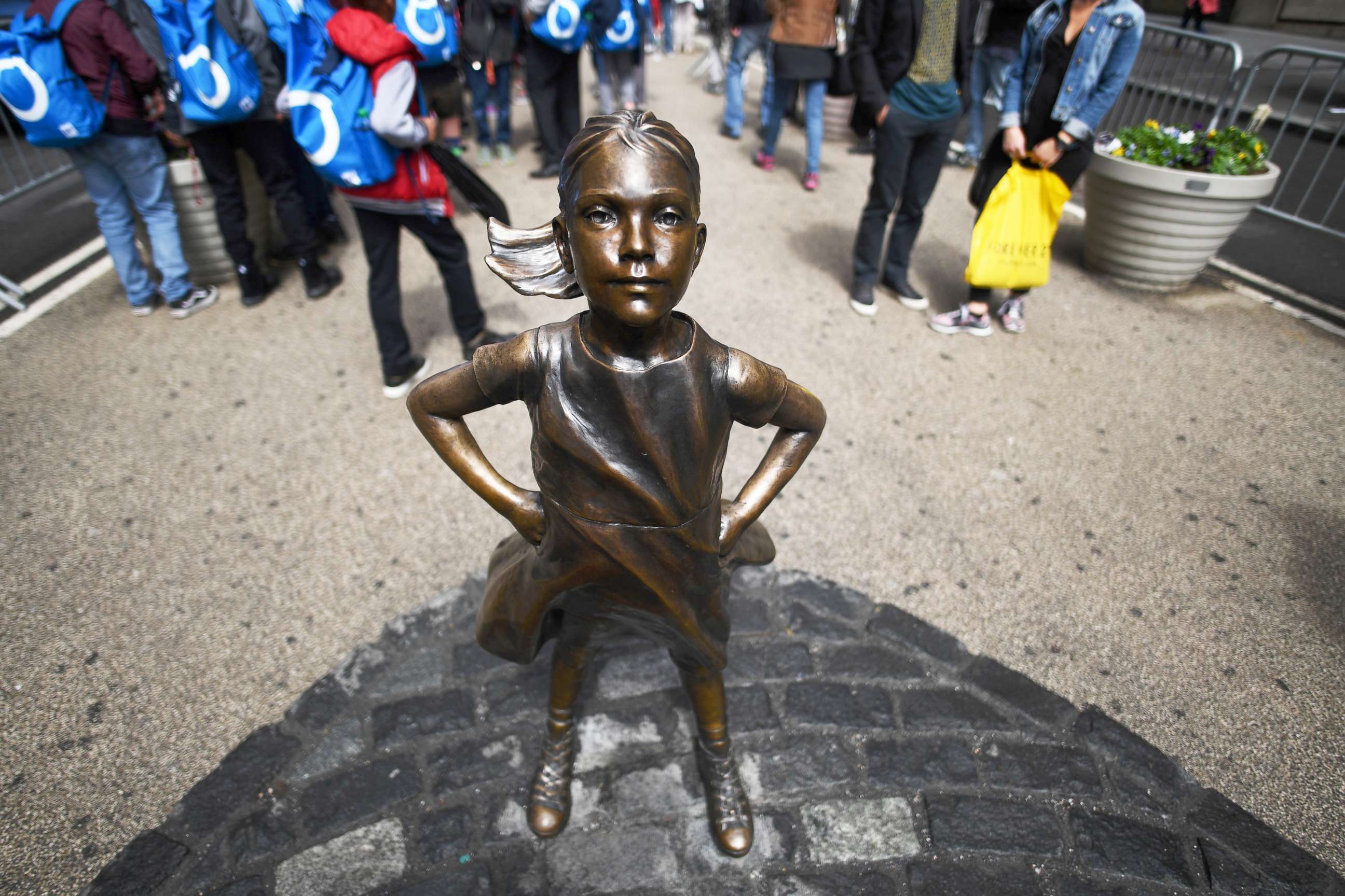 PHOTO: The "Fearless Girl" statue stands facing the "Charging Bull" as tourists take pictures in New York City, April 12, 2017.