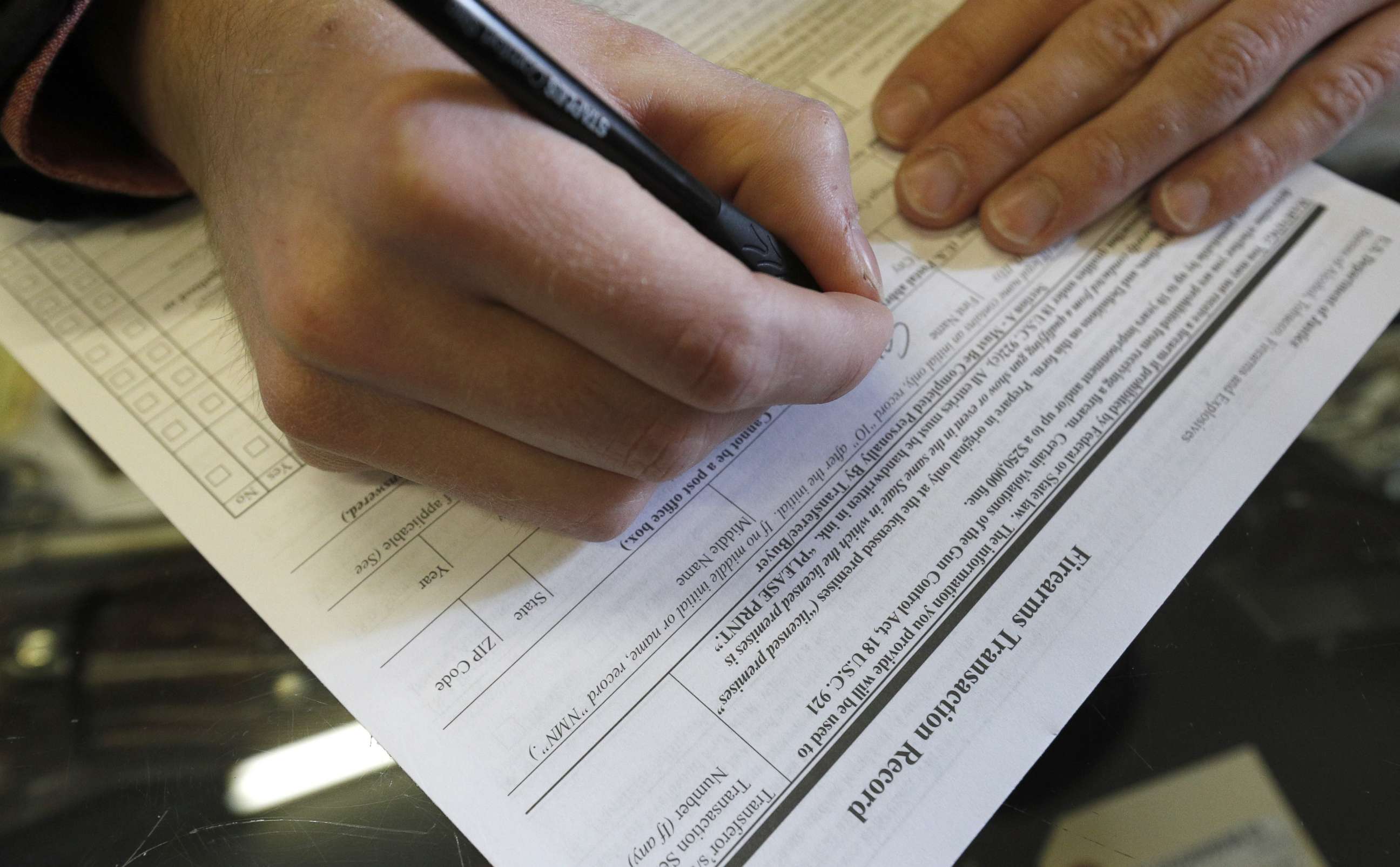 PHOTO: A man fills out a federal background check form at a gun retailer on Feb. 15, 2018 in Orem, Utah.