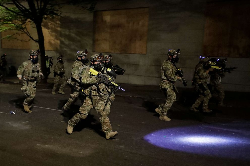 PHOTO: Federal officers advance on retreating demonstrators after an illegal assembly was declared during a Black Lives Matter protest at the Mark O. Hatfield United States Courthouse, July 29, 2020, in Portland, Ore.