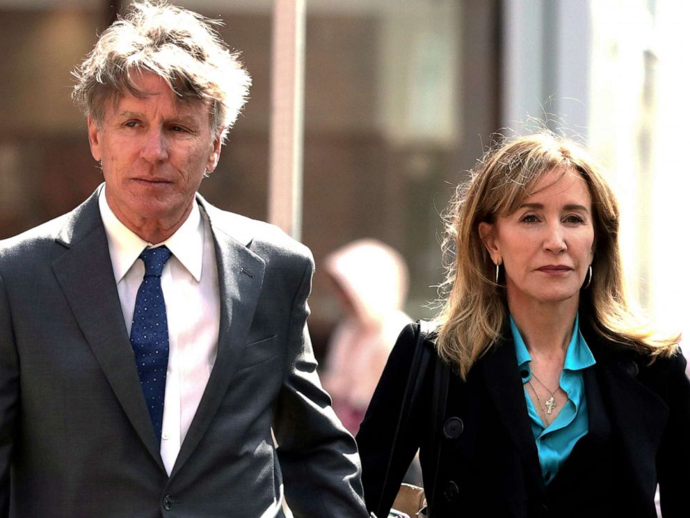 PHOTO: Felicity Huffman arrives holding hands with her brother Moore Huffman Jr., left, at federal court in Boston on Wednesday, April 3, 2019, to face charges in a nationwide college admissions bribery scandal.