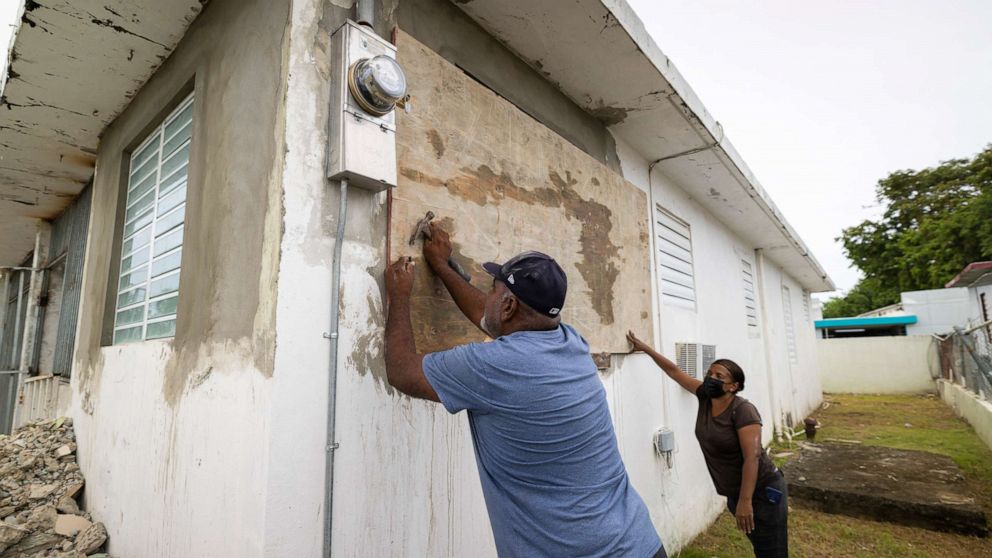 PHOTO: Residents attach protective plywood to a window of their home in preparation for the arrival of Tropical Storm Fiona, in Loiza, Puerto Rico, Sept. 17, 2022.