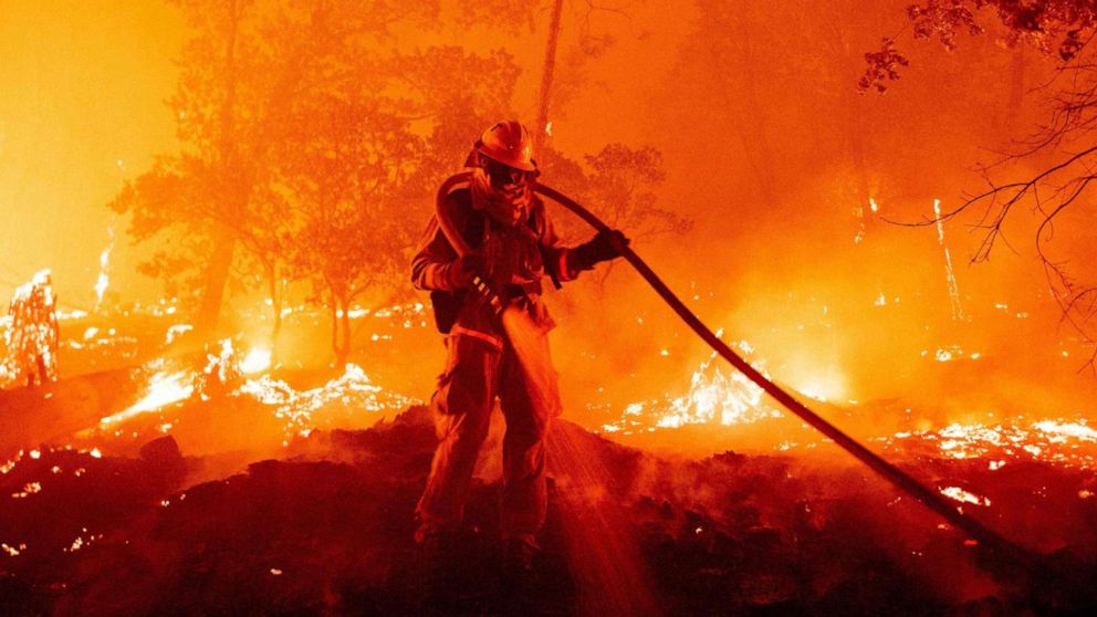 PHOTO: A firefighter douses flames as they push towards homes during the Creek fire in the Cascadel Woods area of unincorporated Madera County, Calif., Sept. 7, 2020. 