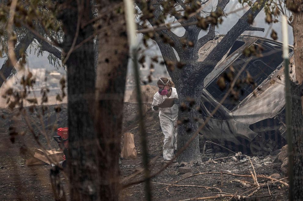 PHOTO: A forensic anthropologist looks for human remains in a damaged vehicle as the McKinney Fire burns near Yreka, Calif., Aug.1, 2022.