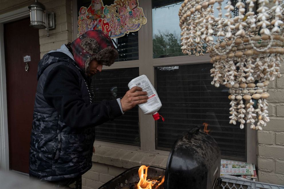 PHOTO: Victor Zelaya tries to start a fire on a barbecue grill during power outage caused by the winter storm on Feb. 16, 2021, in Houston.