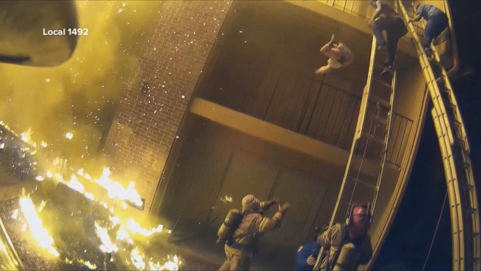 PHOTO: In a video caught by a helmet camera, firefighter Capt. Scott Stroup catches a young child dropped by a parent who was climbing down a ladder from a third-floor balcony early on Jan. 3, 2018.