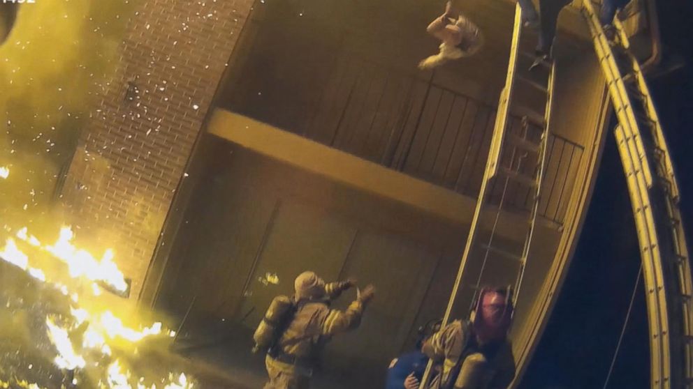 PHOTO: In a video caught by a helmet camera, firefighter Capt. Scott Stroup catches a young child dropped by a parent who was climbing down a ladder from a third-floor balcony early on Jan. 3, 2018.