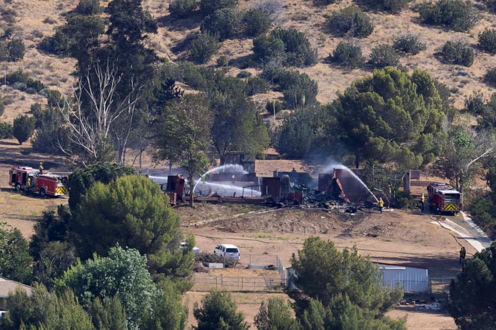 PHOTO: Firefighters douse water on a home after a firefighter shot one colleague to death and severely wounded another at their Los Angeles County firehouse, in Acton, Calif. June 1, 2021. 