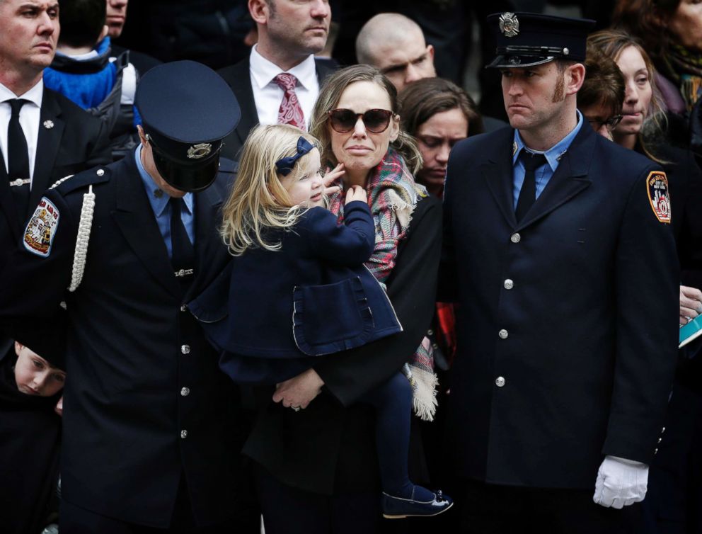 PHOTO: Eileen Davidson, wife of firefighter Michael Davidson, holds her daughter Emily during his funeral at St. Patrick's Cathedral in New York, March 27, 2018.