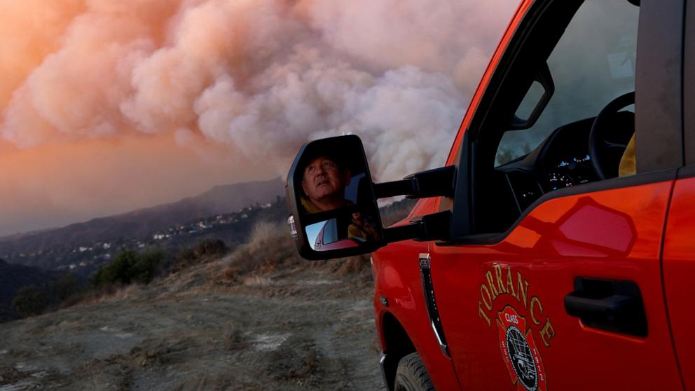 PHOTO: Alec Miller from the Torrance Fire Department looks at the smoke billowing from the Palisades Fire threatening homes in the Brentwood area of Los Angeles, Jan. 11, 2025.  