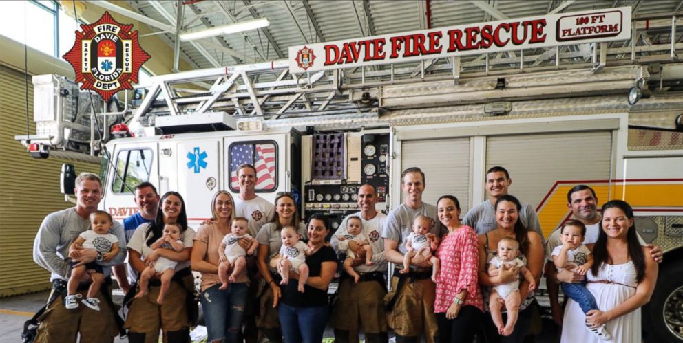 Firefighters in Davie, Fla, pose for a group photo with family members and babies all born in less than a year.
