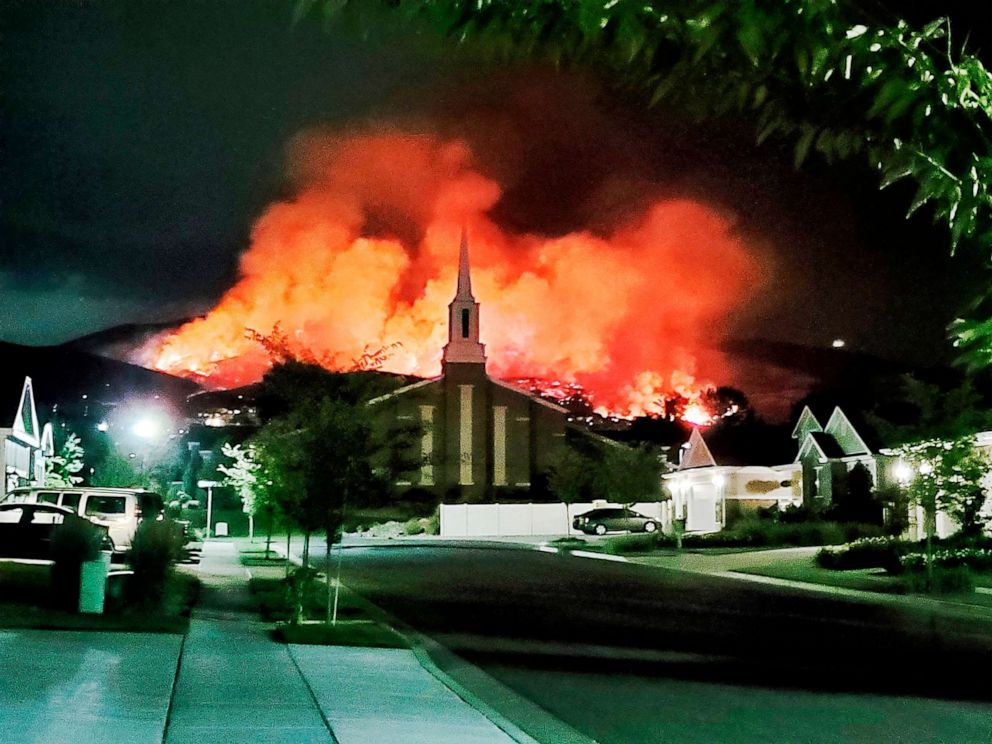 PHOTO: The Traverse Fire burns behind homes in Lehi, Utah,June 28, 2020. Officials say fireworks caused the wildfire and forced evacuations.