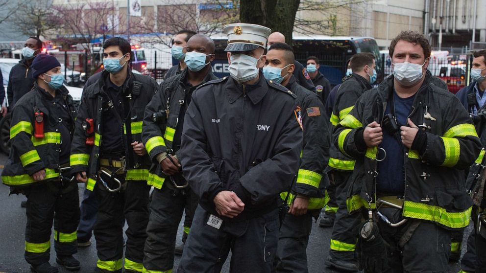 PHOTO: Firemen wearing protective masks watch the 7pm salute to healthcare workers amid the COVID-19 pandemic led by Mayor Bill De Blasio and his wife Charlene McCray on April 24, 2020 in Brooklyn, New York.
