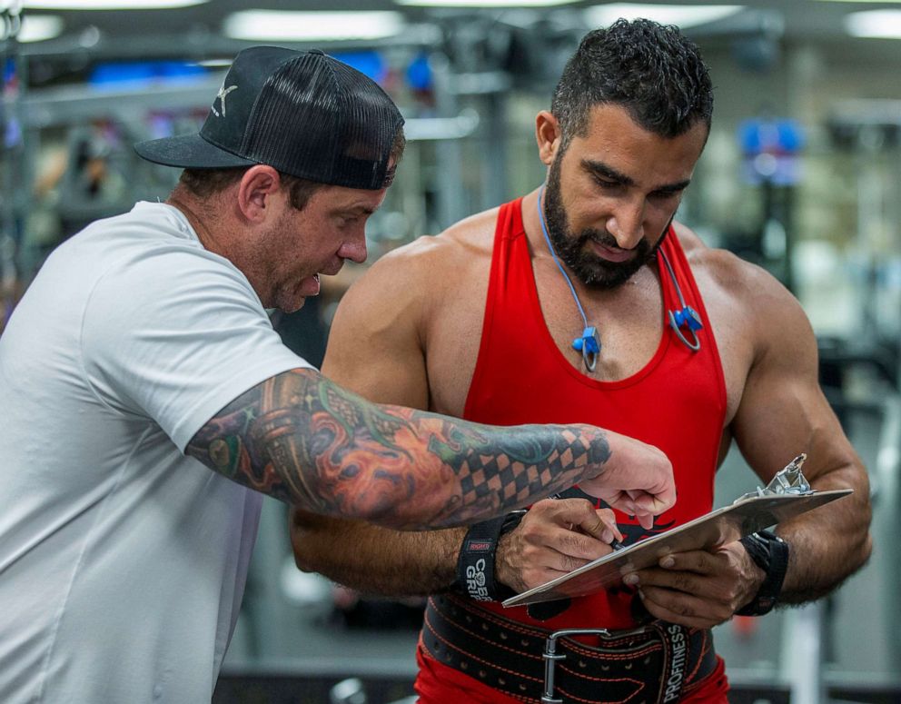 PHOTO: Fitness Mania Owner Mike Ends, left, shows Yaser Jabbar were to sign on the recall form for Gov. Gavin Newsom, who ordered gyms closed to help slow the spread of the novel coronavirus in Riverside, Calif., July 14, 2020.