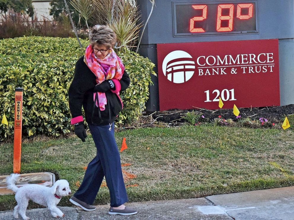 PHOTO: A woman walks her dog near a temperature sign reading 28 degrees in Winter Park, Fl, Jan. 30, 2022. Florida had its coldest weather in a decade, with temperatures near or below freezing in many parts of the state.