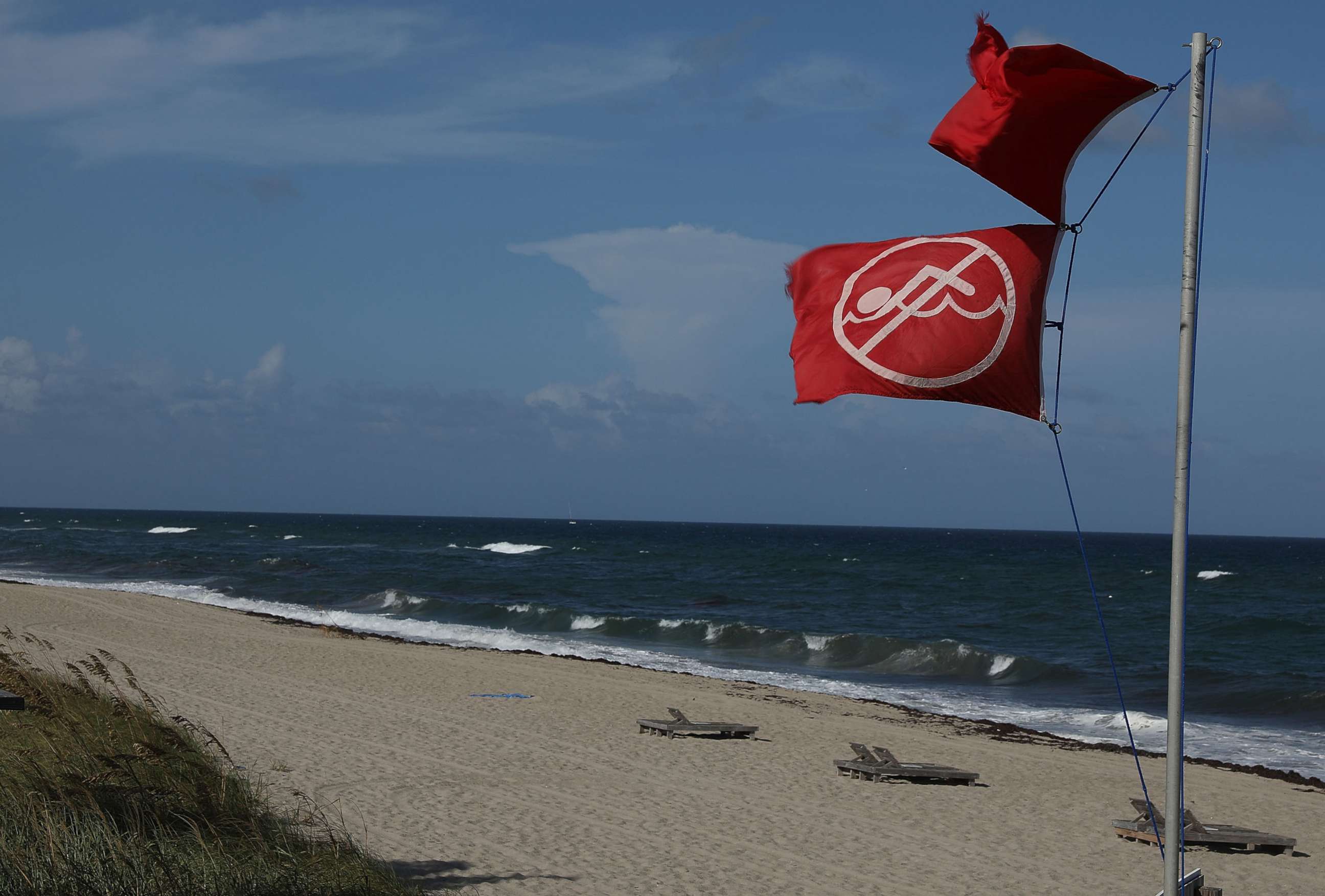 PHOTO: A lifeguards' no swimming flag flies above a beach as Palm Beach County as officials announced that all county beaches are closed due to red tide affecting coastal areas on Oct. 4, 2018 in Lake Worth, Fla.
