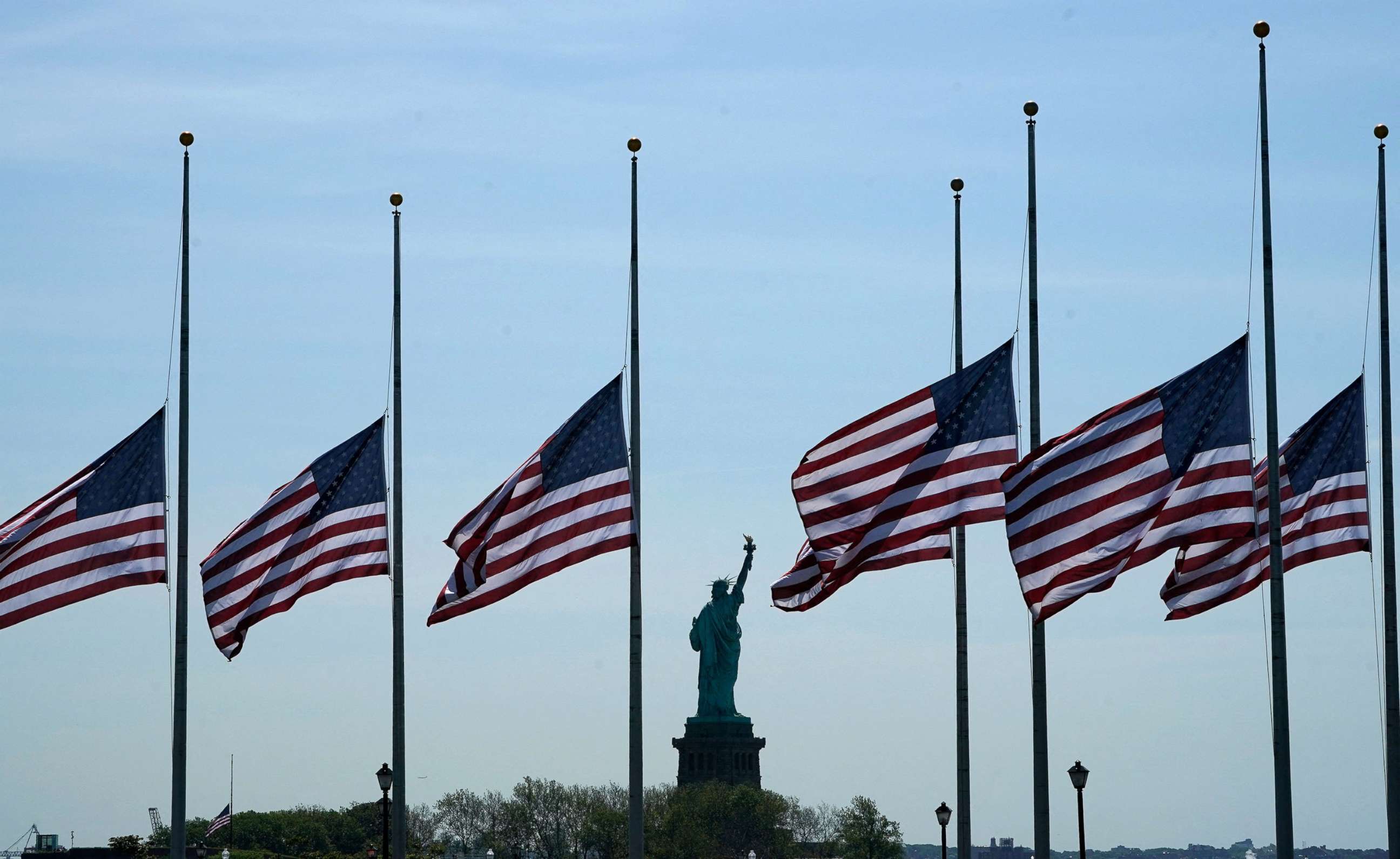 PHOTO: American flags fly at half-mast at Liberty State Park in Jersey City, N.J., across New York Bay from the Statue of Liberty, May 25, 2022, as a mark of respect for the victims of the May 24 shooting at Robb Elementary School in Uvalde, Texas.