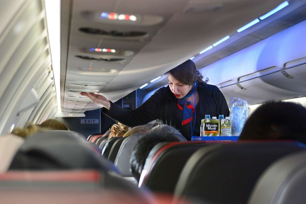 PHOTO: An American Airlines flight attendant serves drinks to passengers after departing  Dallas/Fort Worth International Airport near Dallas, Dec. 12, 2018.