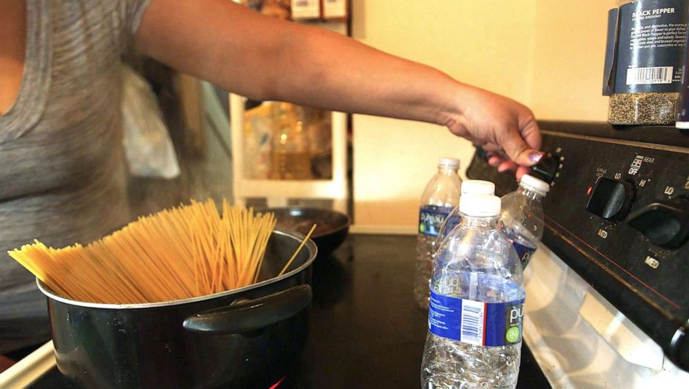 PHOTO: Jamie Marshall says she won't use the water in Flint, Mich., for cooking, so she uses four bottles of water to boil spaghetti for dinner.