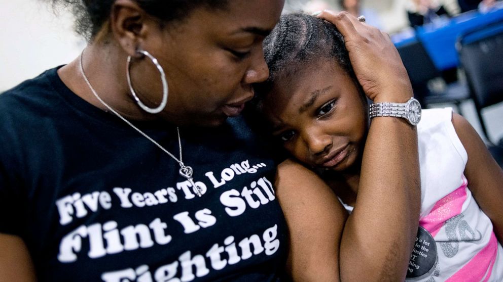 PHOTO: Flint resident Ariana Hawk consoles her daughter Aliana, 4, during a community meeting with Flint water prosecutors, June 28, 2019, in Flint, Mich.