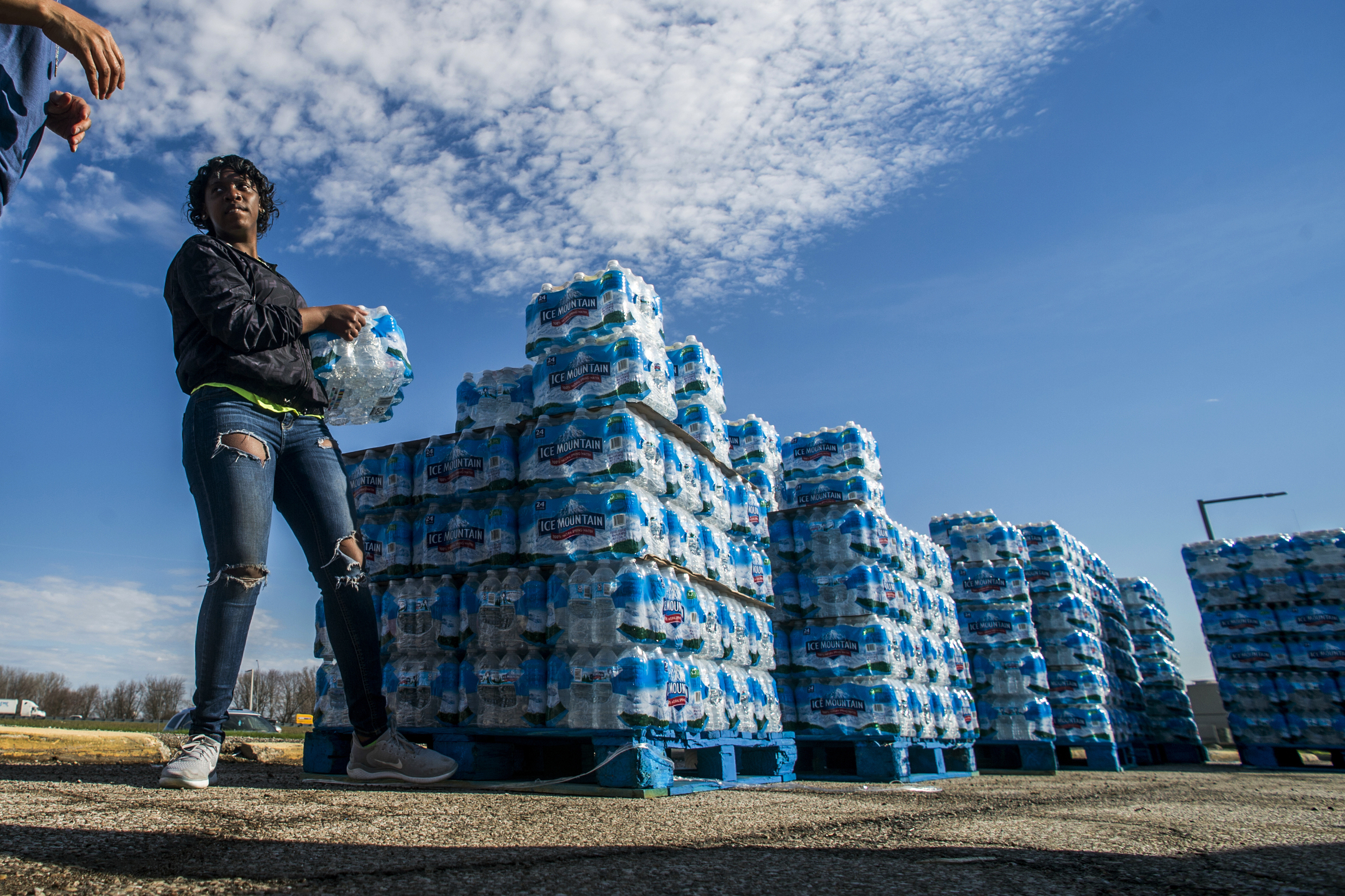 PHOTO: Volunteers load cases of water into vehicles in Flint, Mich., April 22, 2020.