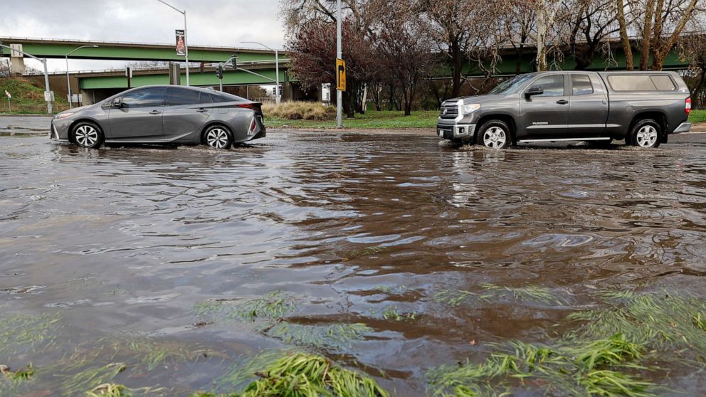 PHOTO: Drivers navigate a flooded street after winter storms brought high winds and heavy rain in Sacramento, California, Jan. 8, 2023.
