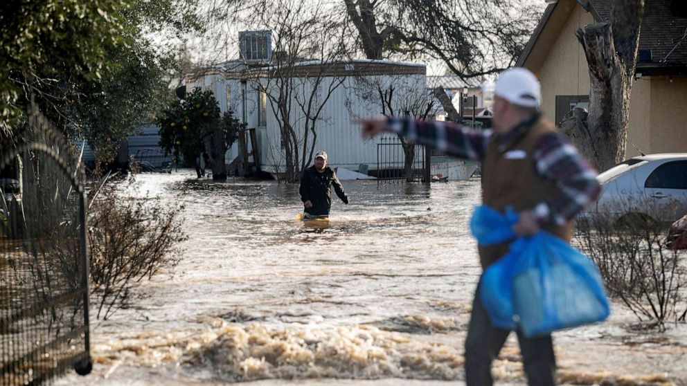 PHOTO: Residents scramble to retrieve belongings before flood waters rise too high Merced, California, on Jan. 10, 2023.