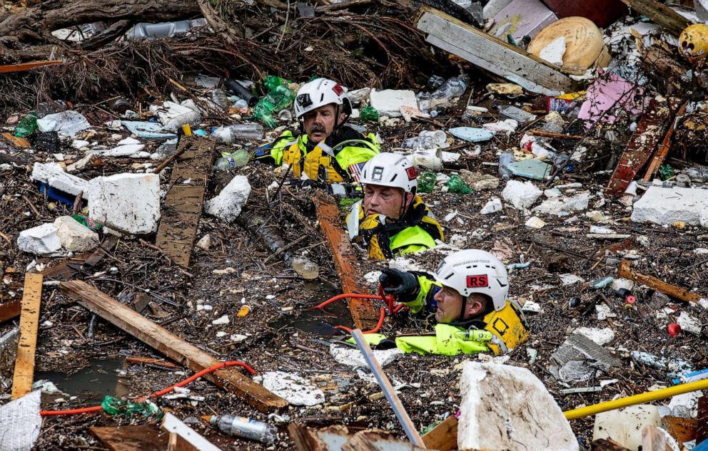 PHOTO: Members of the Tennessee Task Force One search and rescue team wade through the debris-filled Troublesome Creek, after a search dog detected the scent of a potential victim in Perry County, Kentucky, on July 31, 2022.