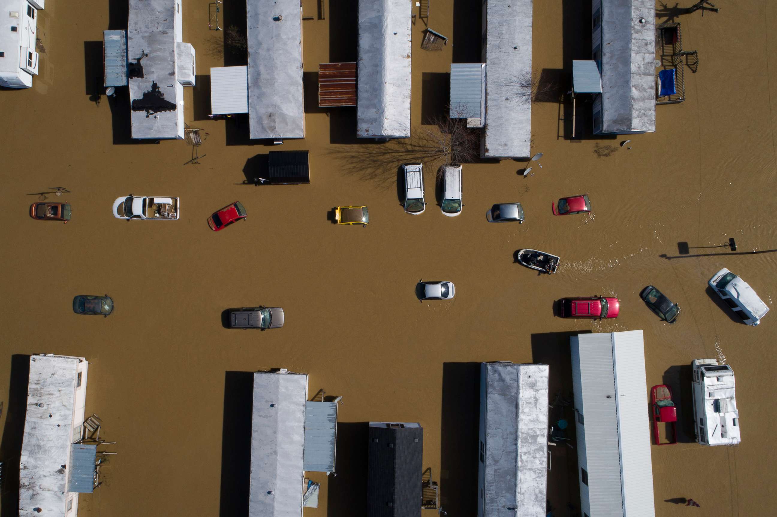 PHOTO: A boat weaves through partially submerged cars and trailers in the city of  following heavy rains which caused the Kentucky River to flood in Beattyville, Ky., March 2, 2021. 