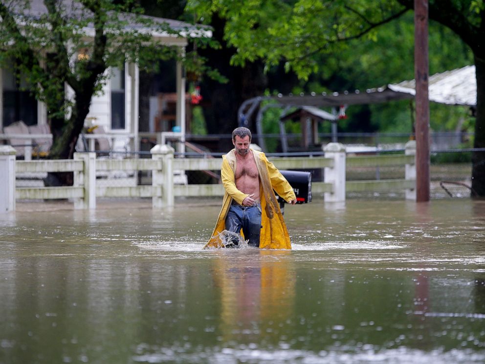PHOTO: David Dick wades out of the water after checking on his flooded home in Sperry, Okla., Tuesday, May 21, 2019.