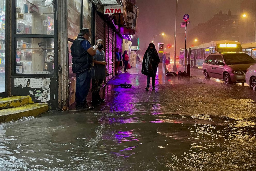 PHOTO: NEW YORK, NY - SEPTEMBER 01: People make their way in rainfall from the remnants of Hurricane Ida on September 1, 2021, in the Bronx borough of New York City. 