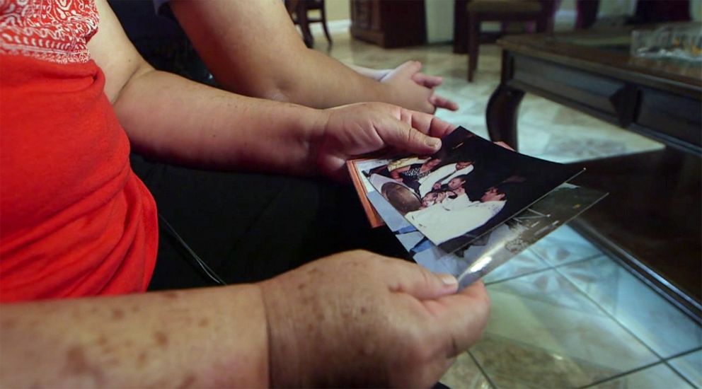 PHOTO: Flor Marquez holds a photo of her son, Adrian, being baptized. She only has three photos left from her life in El Salvador.