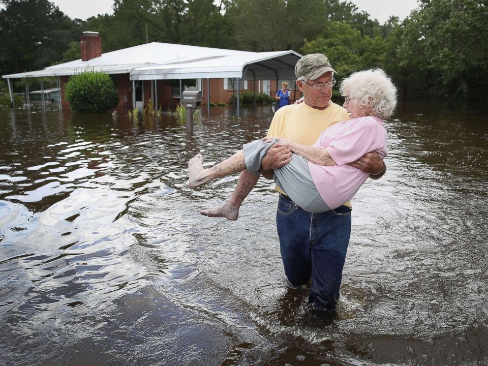PHOTO: Bob Richling carries Iris Darden as the Little River water begins to seep home on September 17, 2018 in Spring Lake, Nova Scotia.