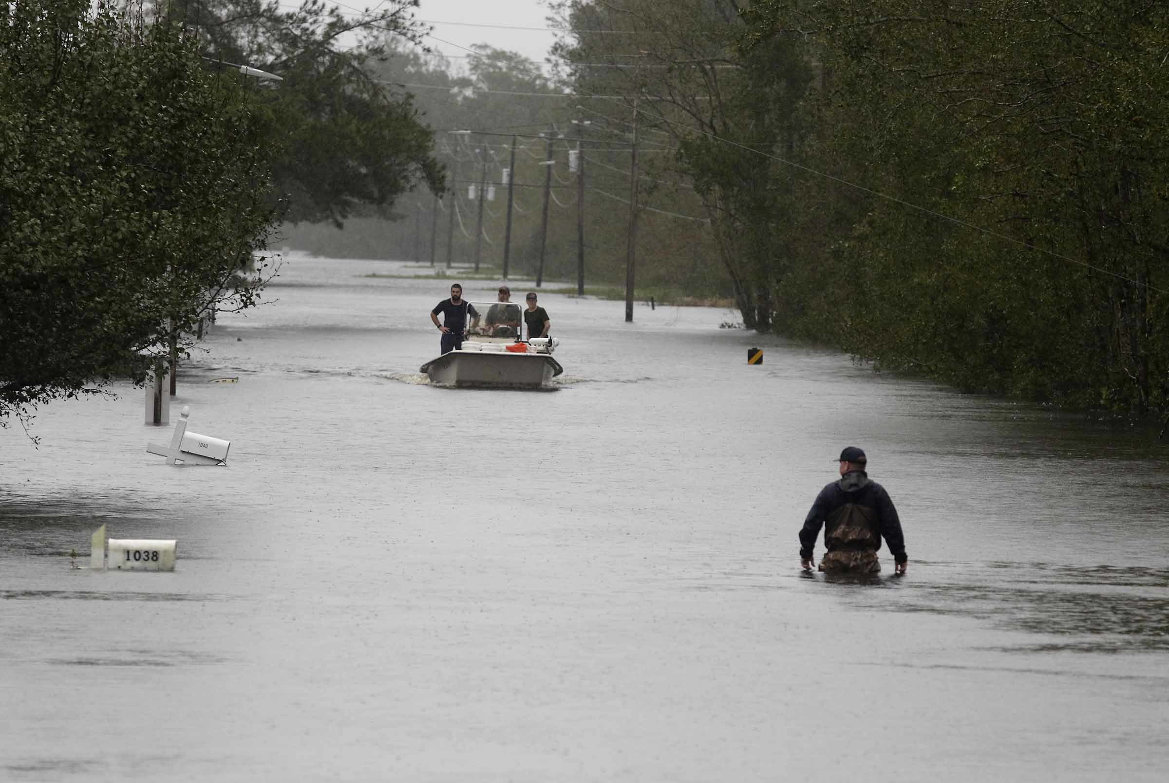 PHOTO: A member of the US Coast Guard walks down Mill Creek Road checking houses after tropical storm Florence hit Newport N.C., Saturday, Sept. 15, 2018.