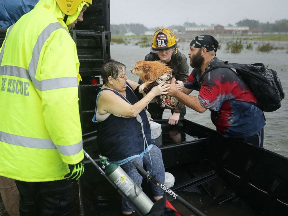 PHOTO: Rescue workers from Township No. 7 Fire Department and volunteers from the Civilian Crisis Response Team help rescue a woman and her dog from their flooded home during Hurricane Florence, Sept. 14, 2018, in James City, N.C.
